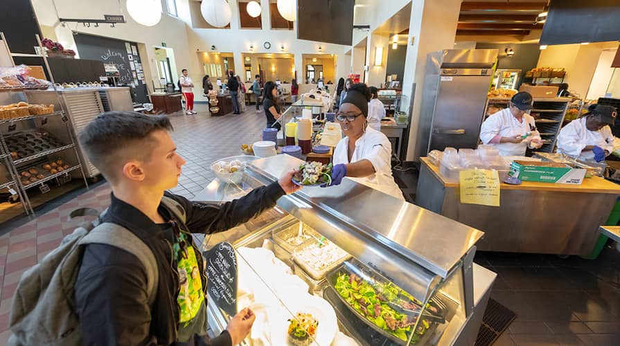 Male student gets food from college dinning hall.